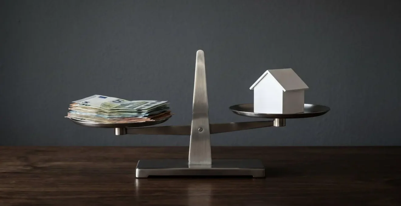 Balance à fléau avec billets d'un côté et maison miniature de l'autre, légèrement déséquilibrée vers l'argent, illustrant l'impact du prix sur la vente.